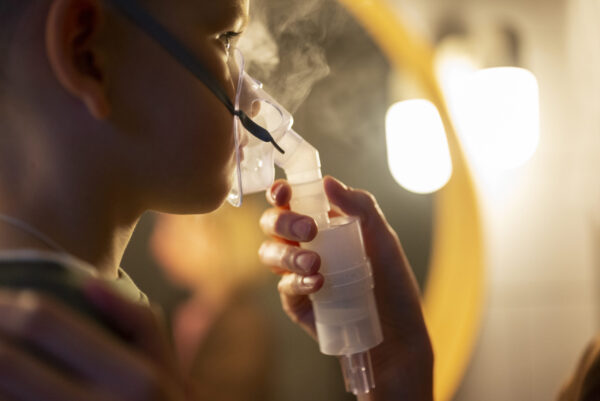 Side view of child using a nebulizer. Designed by Freepik